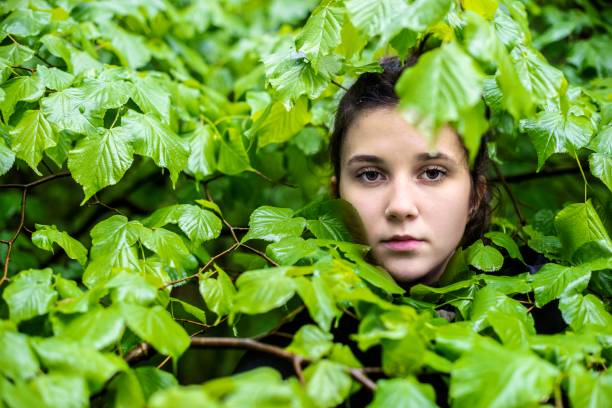 istock A young girl hiding in the forest 1223503806