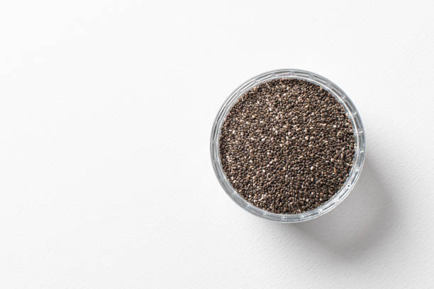 Chia seeds in a cup beautifully laid out on a white background. Top view. copy space.. Vegetarian food. Chia seeds in a cup beautifully laid out on a white background. Top view. copy space.. Vegetarian food. Unprepared. chia seed photos stock pictures, royalty-free photos & images