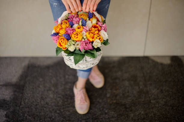 istock Woman holds a decorative basket with different bright flowers. 1223506919