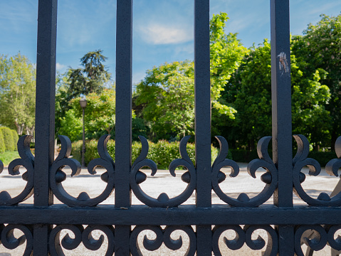 Metal gate railing with heart-shaped symbol giving access to an outdoor park