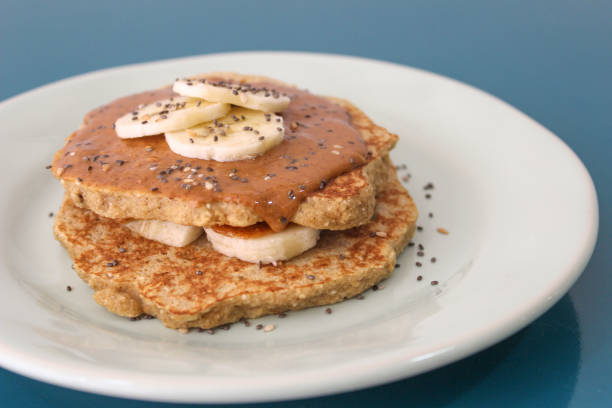Oat pancakes with peanut butter and banana Oat pancakes with peanut butter and banana on a blue plate apple cinnamon pancake stock pictures, royalty-free photos & images