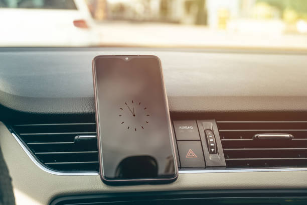 istock black screen smartphone in the vehicle center console, with clock 1223517421