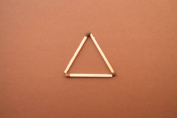 Isosceles triangle on a bright background. matchstick pyramid on cardboard. Education concept Isosceles triangle on a bright background. matchstick pyramid on cardboard. Education concept. isosceles triangle stock pictures, royalty-free photos & images