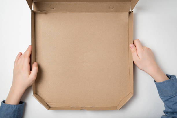 istock Empty open box of pizza in children's hands on white background. Top view. Copy space. 1223519340