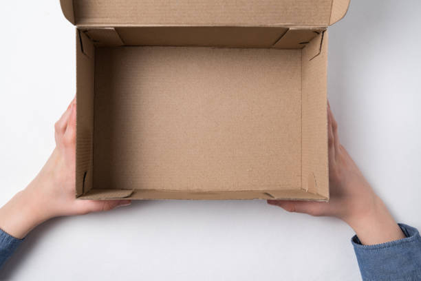 istock Children's hands holding an open cardboard box. Empty box, white background. 1223519359