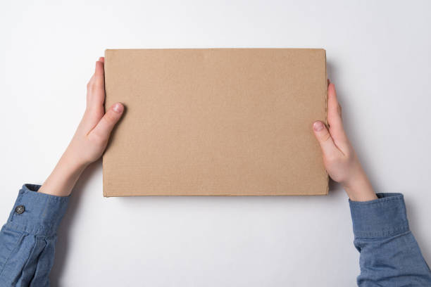 istock Craft paper box in children's hands on white background. Top view. Copy space. 1223519368