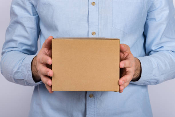 istock Man holding cardboard box. Delivery service. close up. copy space. mockup. 1223519938