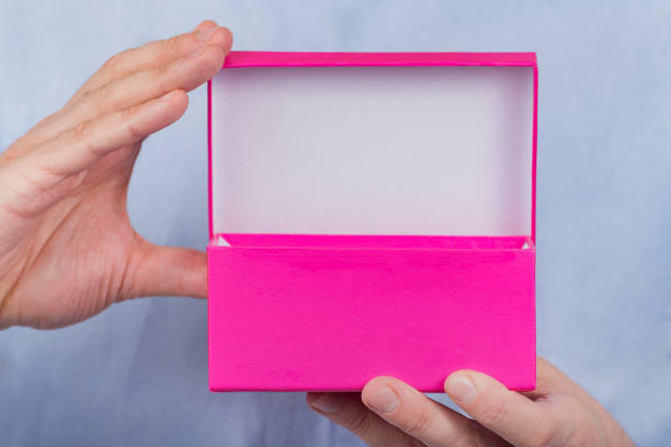 istock Open pink box in the men's hands. Front view. Close up. Copy space. Moke up 1223519953