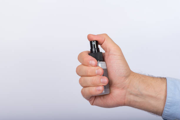 istock Small spray bottle in male hand. White background. Antimicrobial protective spray. 1223519981