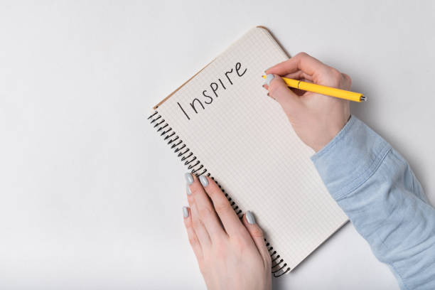 istock INSPIRE inscription. Female writing in Notepad. Copybook on white background. 1223520977