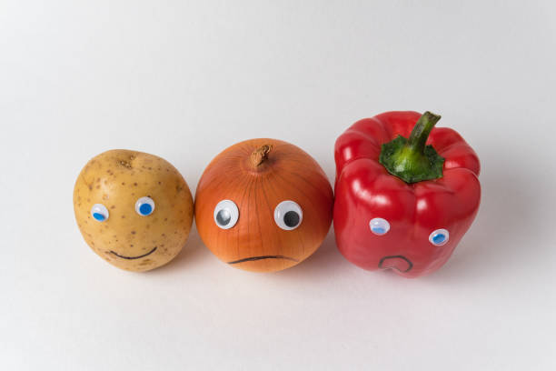 istock Potatoes, onions and peppers with funny faces. White background top view. concept is different from the others 1223522531