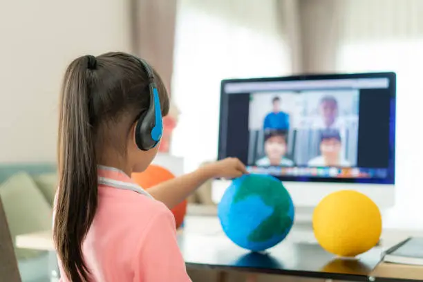 Asian girl student live learning video conference with teacher and other classmates giving presentation, showing solar model project, Homeschooling and distance learning ,online ,education and internet.