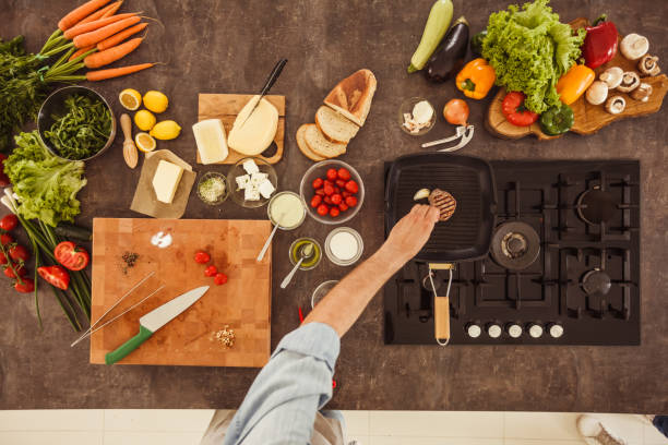 istock Man adding a clove of garlic into a pan where he is cooking a steak 1223524032