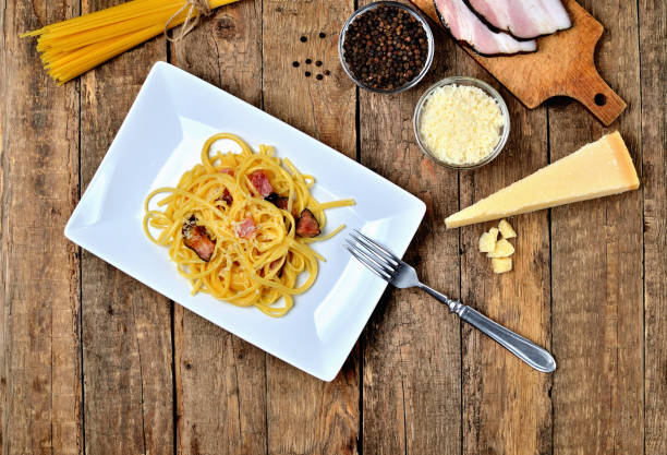 istock Spaghetti Carbonara pasta, with bacon, parmesan cheese, egg. Pasta alla carbonara, Traditional italian cuisine. Top view. 1223524727
