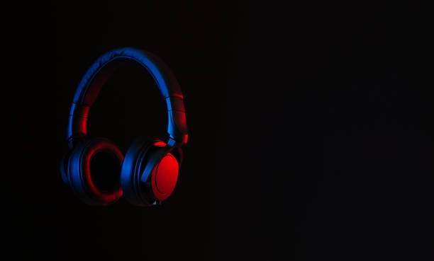 black headphones lit with red and blue neon - brightly lit audio imagens e fotografias de stock