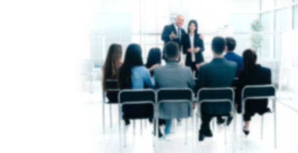 istock boss representing a young specialist during a work meeting. Background for text with people in blur 1223526480