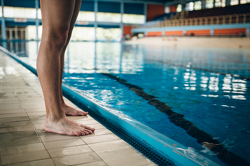 Young male sportist jumping in the swimming pool
