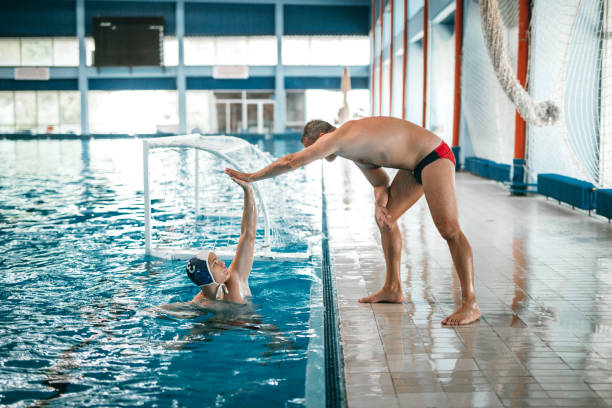 istock Coach and athlete at swimming classes high fiving 1223527426