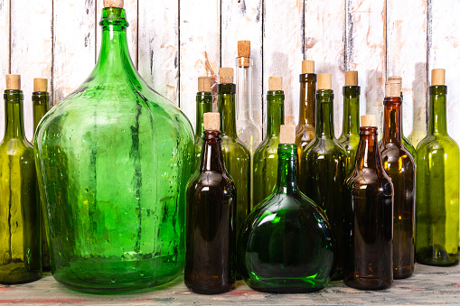 many glass bottles of different colors and sizes for fine wine