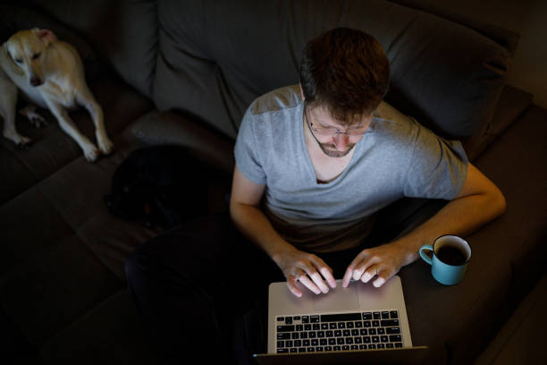 istock Man typing on laptop late night 1223531588