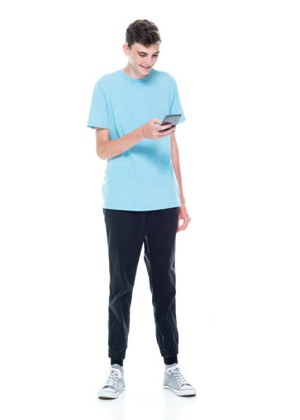 istock Caucasian boys standing in front of white background and using mobile phone 1223536997