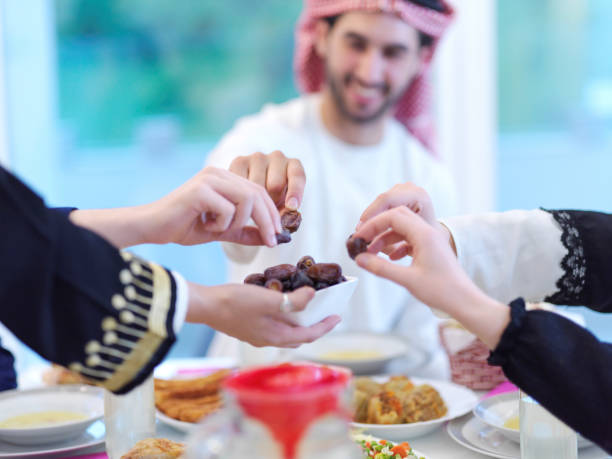 istock Muslim family having Iftar dinner eating dates to break feast 1223544040