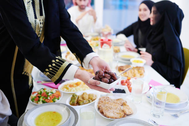 istock Muslim family having Iftar dinner eating dates to break feast 1223544055