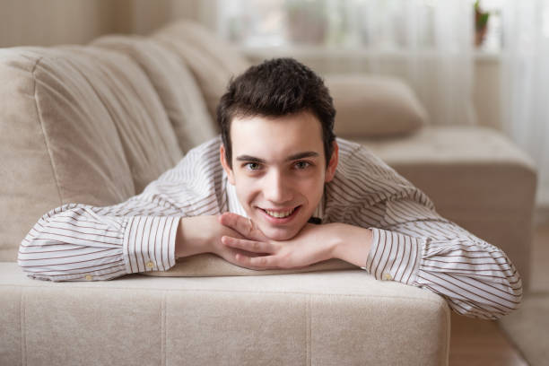 istock Teenager young man lying on sofa at home 1223545864