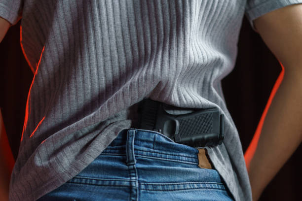 istock Man hiding his gun in his jeans on black background. 1223549931