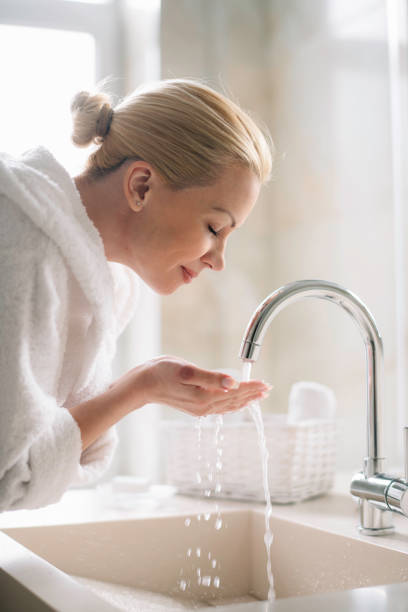 istock Young happy women in bathrobe wash her face. 1223550251