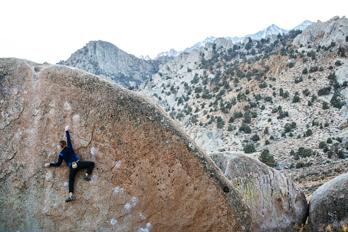 Rock climber bouldering in Bishop California in the Sierra Nevada Mountain Range in California
