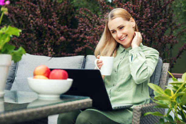 istock young smiling woman using laptop on a terrace 1223558919