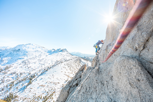 Female rock climber leading a multi pitch trad climb in Yosemite national park in california in the Sierra Nevada Mountain range