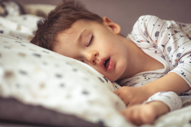 istock Little baby boy sleeping while lying on couch at home 1223560132