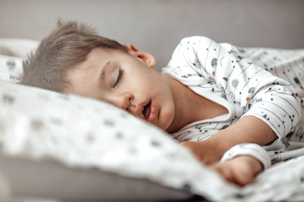 istock Little baby boy sleeping while lying on couch at home 1223560169