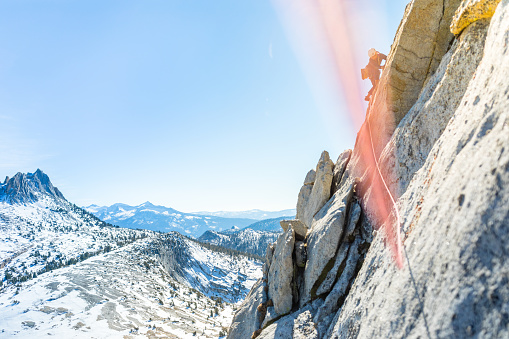Female rock climber leading a multi pitch trad climb in Yosemite national park in california in the Sierra Nevada Mountain range