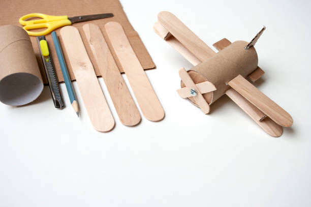 How to make airplane from toilet paper roll and popsicle sticks. Zero waste DIY. Decoration for child room, skill share. Handmade ideas during quarantine. How to make airplane toy from toilet paper roll and popsicle sticks. Zero waste DIY. Decoration for child room, skill share. Handmade ideas during quarantine. Copy space. popsicle stick stock pictures, royalty-free photos & images
