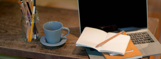 istock Cropped shot of rustic worktable with laptop, notebooks, stationery and coffee cup 1223562532
