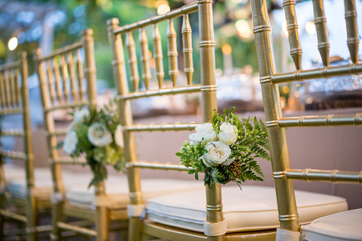 Decoración de flores en sillas para la recepción de la boda en el jardín photo