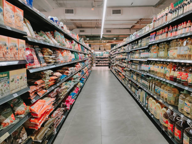 interno di un supermercato pieno di generi alimentari in file con scaffale visualizzato - supermercato foto e immagini stock