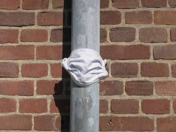 istock rain pipe dressed up with a face mask at a red brick wall 1223566121