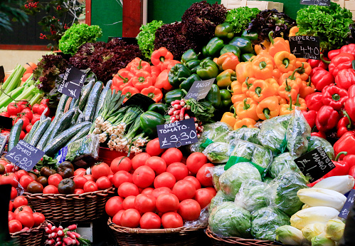 Numerous vegetables and herbs for sale on the counter of a farmer with an organic eco harvest on the local market