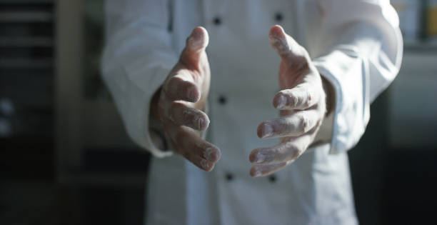 A chef prepares the ingredients like flour and eggs to make fresh pasta according to the ancient Italian tradition.