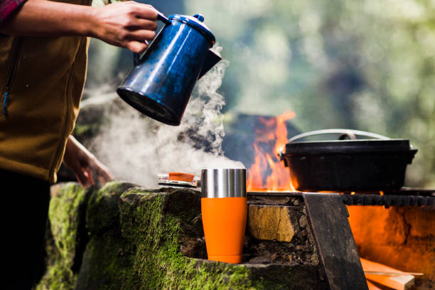 istock Pouring morning coffee from a pot while camping in the woods 1223568801