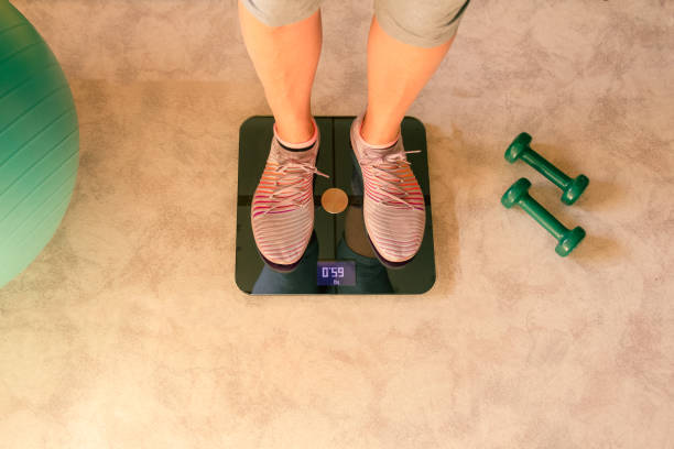 여자의 발은 집에서 저울에 무게가되고. 홈 트레이닝 컨셉. 격리 개념 - dieting overweight weight scale help 뉴스 사진 이미지