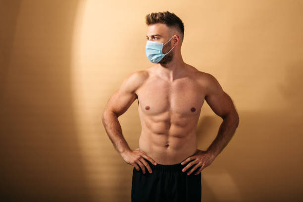 istock Young muscular male posing in studio with mask on his face 1223572130