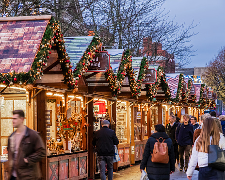 People strolling among the individually designed alpine chalets at the Christmas market of Southampton.