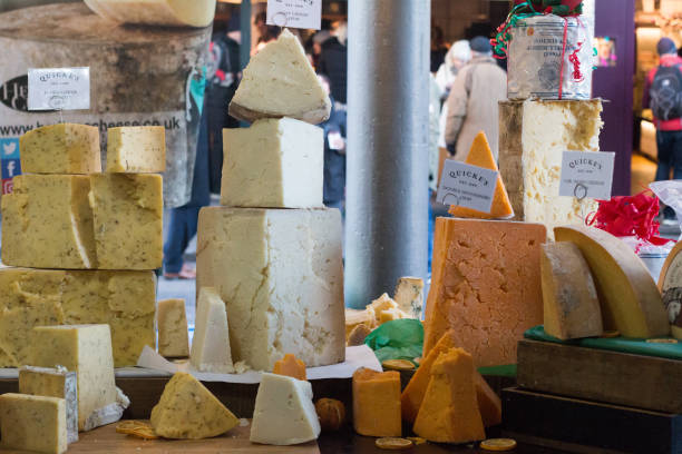 Individually wrapped slices of cheese are stacked on a table at the daily farmer's market