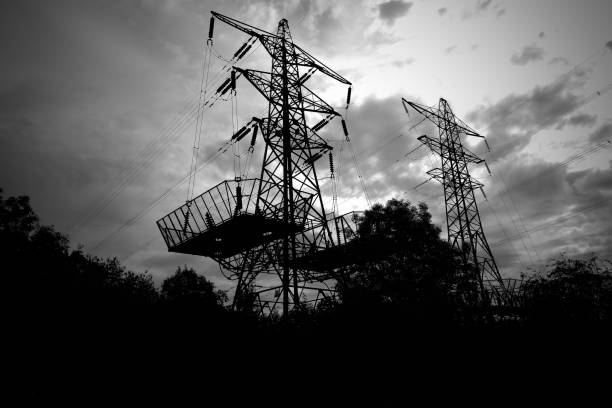 Silhouette of electricity pylon towers stock photo