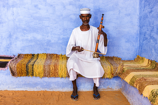 Muslim man playing a rebab in Nubian Village near Aswan, Southern Egypt, Africa. The rebab is a string instrument spread via Islamic trading routes over much of North Africa and the Middle East.